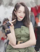 吴宣仪对镜头展示新学手势，眼眸含笑散发自信光彩