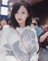 吴宣仪低头浅笑，粉色链条包成为整体简约穿搭中的一抹亮眼点缀