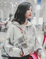 吴宣仪侧身行走，卫衣下摆微扬，牛仔短裤毛边细节与修长腿部线条一览无遗