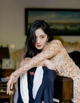 杨幂侧身回眸，暖阳穿过发丝，连衣裙的露背设计展现其光滑美背与优雅颈部曲线