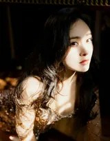 杨幂坐于光影交织的沙发上，一袭修身长裙展现曼妙身姿，裙摆开叉处美腿线条若隐若现