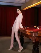 杨幂侧身倚靠在墨绿色台球桌边，指尖轻触球杆，粉色亮片西装在灯光下如星河倾泻，眼神中流露出慵懒而专注的迷人气息