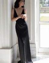 殷桃侧身回眸，黑色深V长裙勾勒出优雅身线，窗外光线为她镀上一层温柔光晕