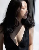 殷桃凭栏而立，微风吹动发丝，她目光深邃凝视镜头，展现独立坚定的女性气质