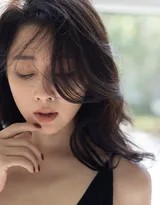 殷桃置身于柔和光线下，轻抚手臂姿态妩媚，深V领口与精致锁骨成为视觉焦点