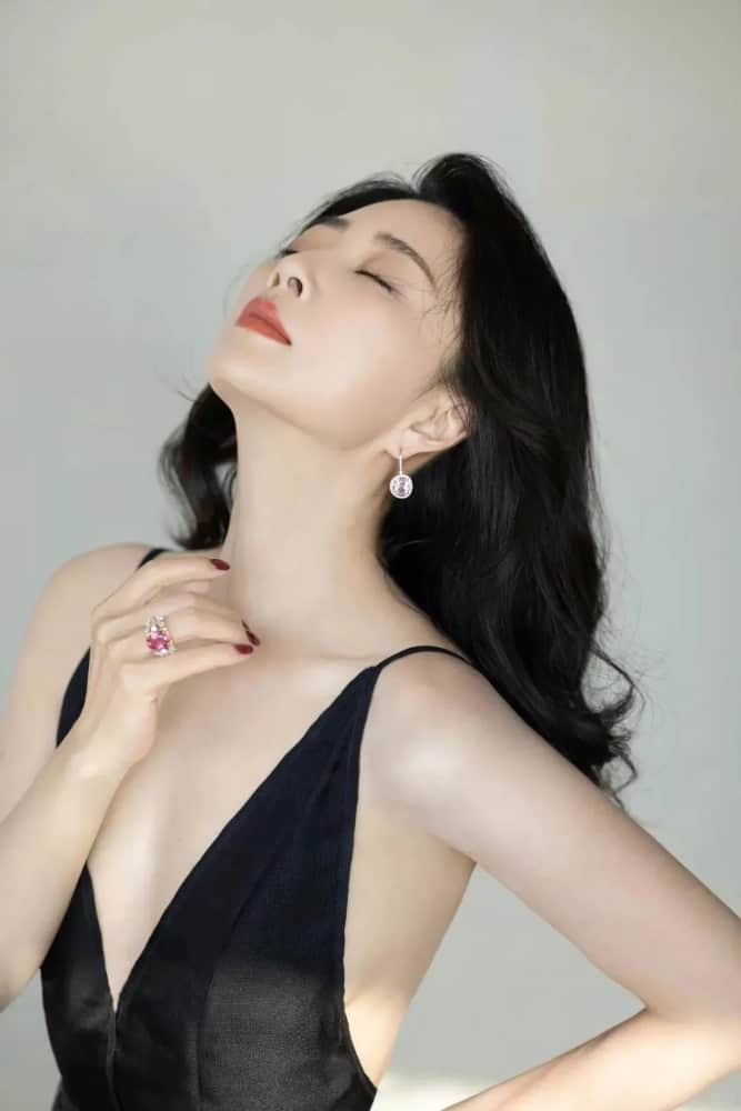 殷桃撩发瞬间尽显妩媚，黑色礼服与精致侧颜勾勒出迷人画面