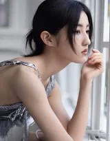 光影勾勒出张子枫优雅的脖颈与锁骨线条，细腻肌肤与冷银色裙装形成质感对比