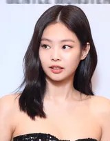 JENNIE优雅转身，展示背后巨型黑色蝴蝶结的完整形态，宛如展开的蝶翼，尽显华丽而大胆的背部设计