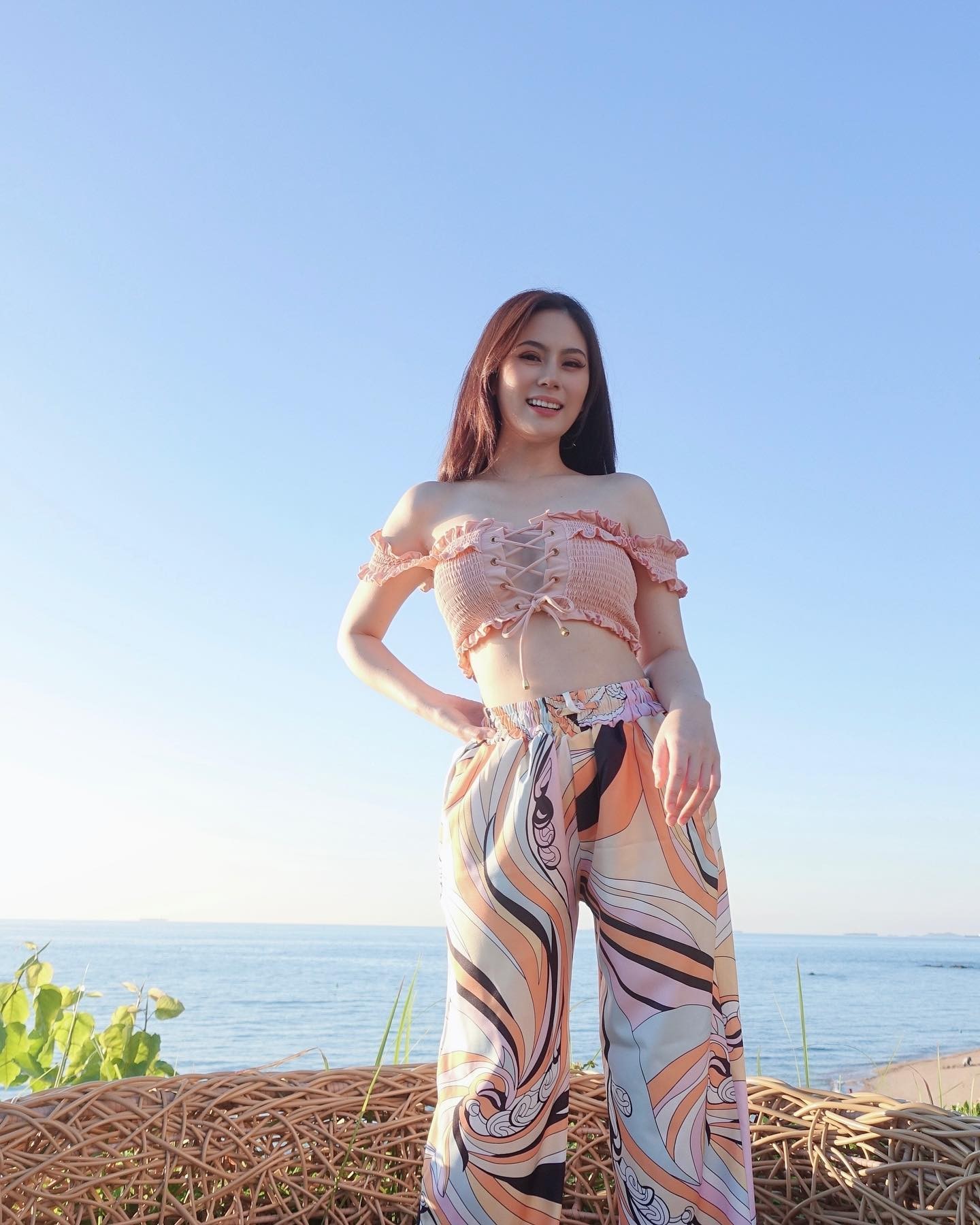 侧身倚靠，眼眸低垂望向下方，浓密睫毛与一抹红唇在特写中构成极致的视觉焦点