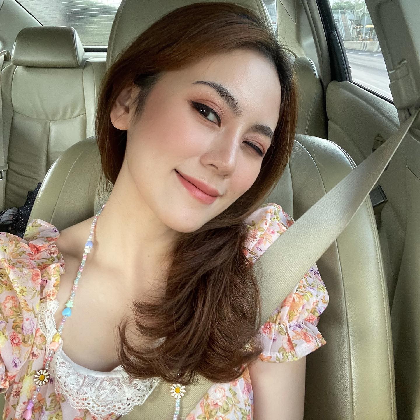 居家氛围中，身着简单吊带的女子望向窗外，神情宁静，散发着不设防的柔和魅力