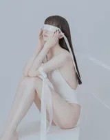 女孩背对镜头舒展双臂，白色连体裤完美展现其背部流畅线条，姿态舒展如舞者，充满优雅的张力