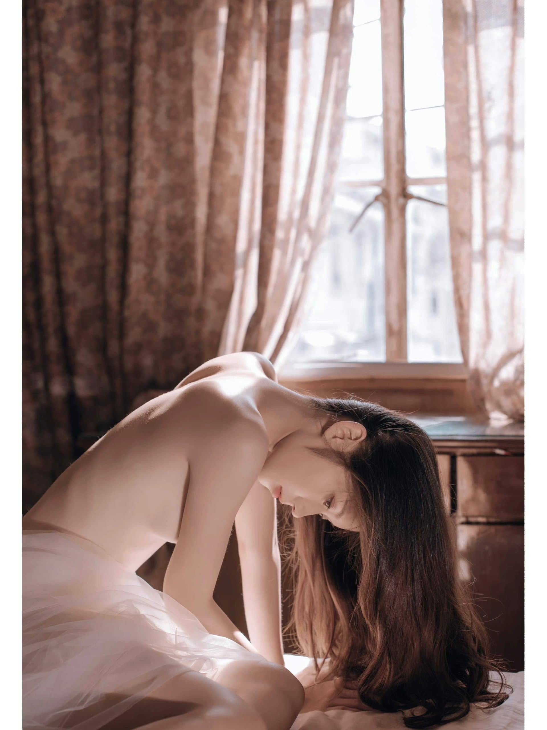 暖阳穿过窗棂，勾勒出居家女子慵懒而温柔的背部曲线