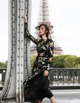 胡冰卿回眸凝望，印花旗袍裙摆随风轻扬，身后巴黎古典建筑若隐若现