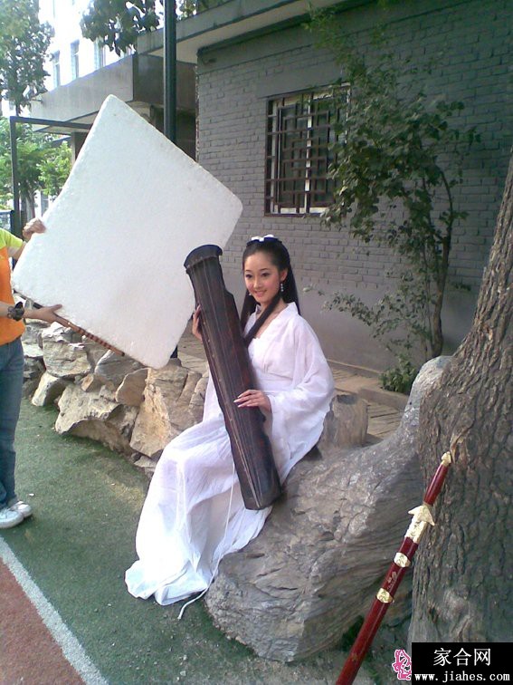 蒋梦婕手持红苹果凝视镜头，丝绒旗袍勾勒窈窕曲线，眼神温柔中带着一丝狡黠