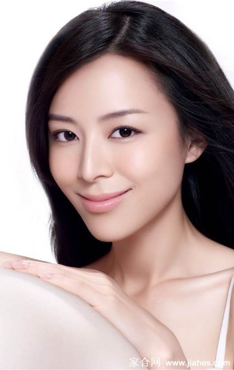 张静初轻抚脸庞眼神迷离，在暖色调光影中散发出迷人的神秘气息