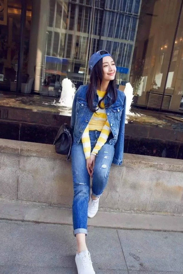 王鸥身着深蓝色修身牛仔背带裙漫步街头，长发披肩气质温婉