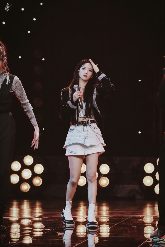 刘些宁与镜头互动笑容甜美，牛仔短裙造型清新活力宛若邻家女孩