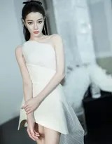 迪丽热巴双手轻拢长发，露出优雅侧颜与天鹅颈，白色裙装更显气质脱俗
