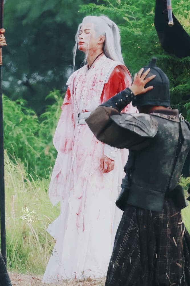 万箭穿心，相柳身中数箭却依然挺立，血色浸染白衣如残阳泣血，眼神决绝而悲怆，身后是战火硝烟，身前是毕生守护的忠义与无法言说的深爱
