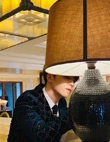 陈立农身着深色丝绒西装正面特写，眼神深邃而平和，双手姿态放松，尽显低调奢华与内在宁静