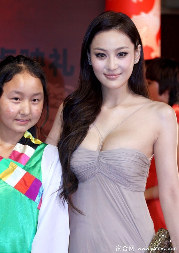 张馨予于暖色调光影中托腮凝视，眼神迷离，卷发散发温柔光泽