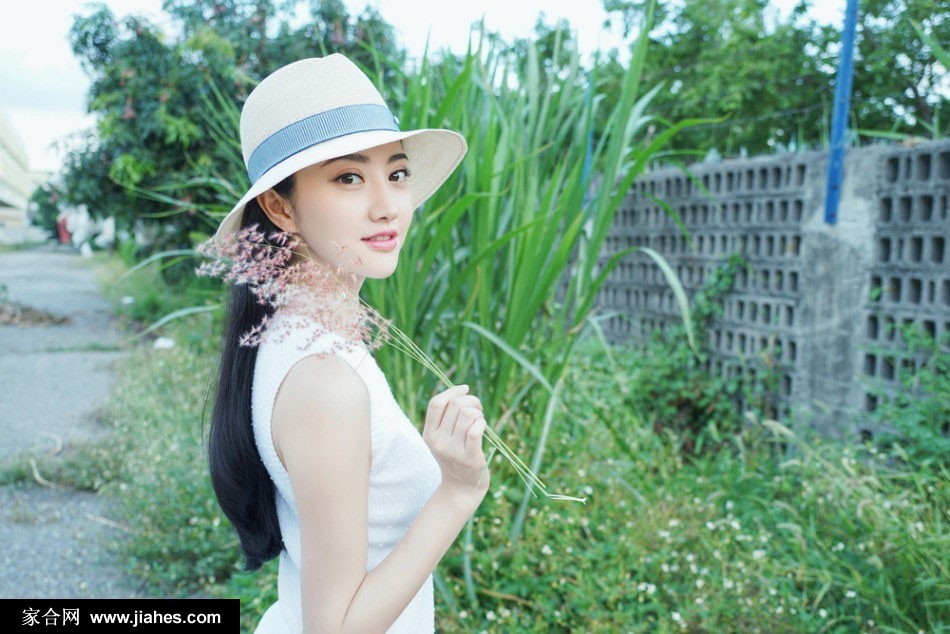 景甜惬意倚靠，白色长裙铺散开，草帽随意放在手边，展现全然放松的度假姿态