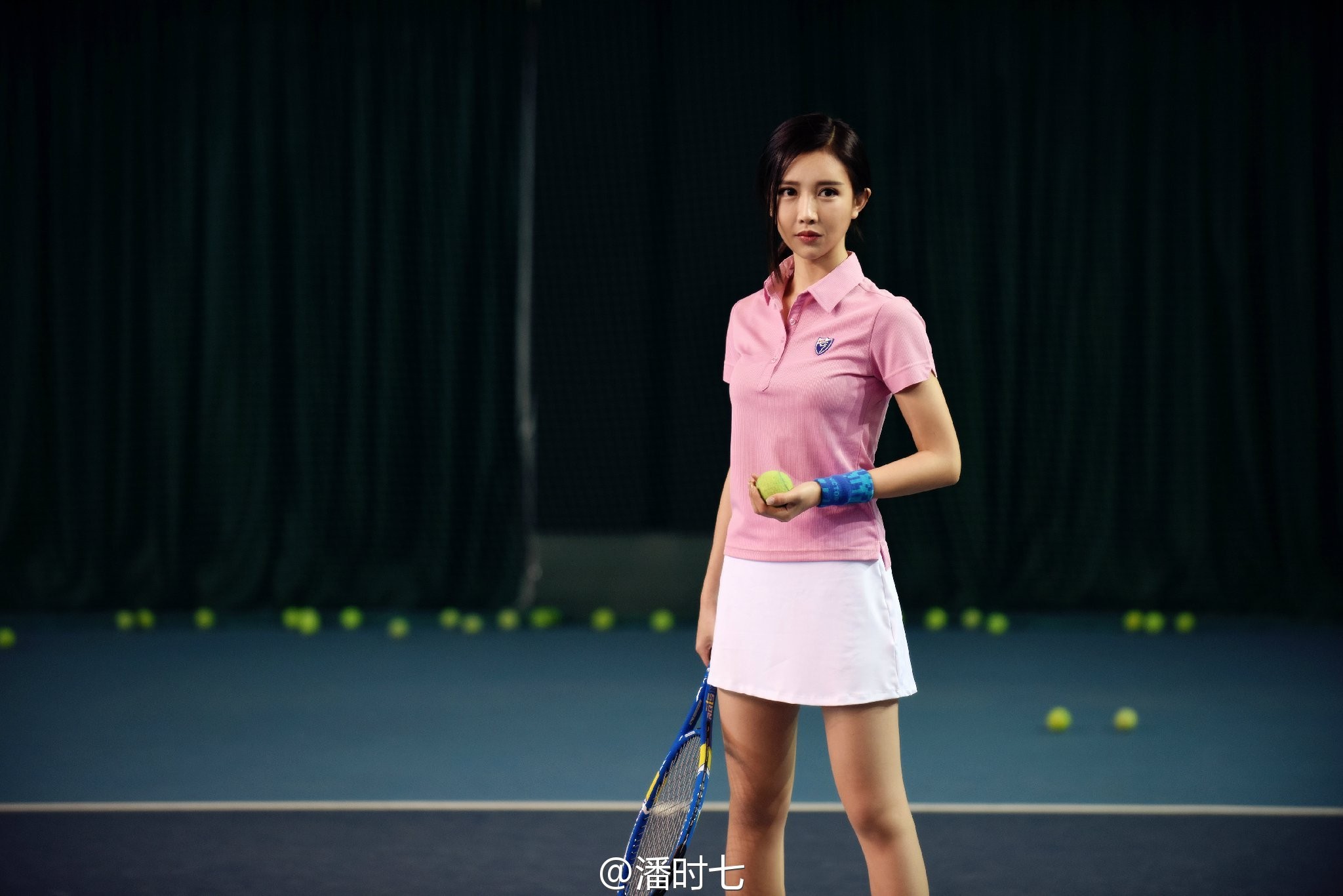 潘时七倚靠墙面，牛仔短裤搭配休闲鞋，随性姿态中散发着迷人的慵懒气息