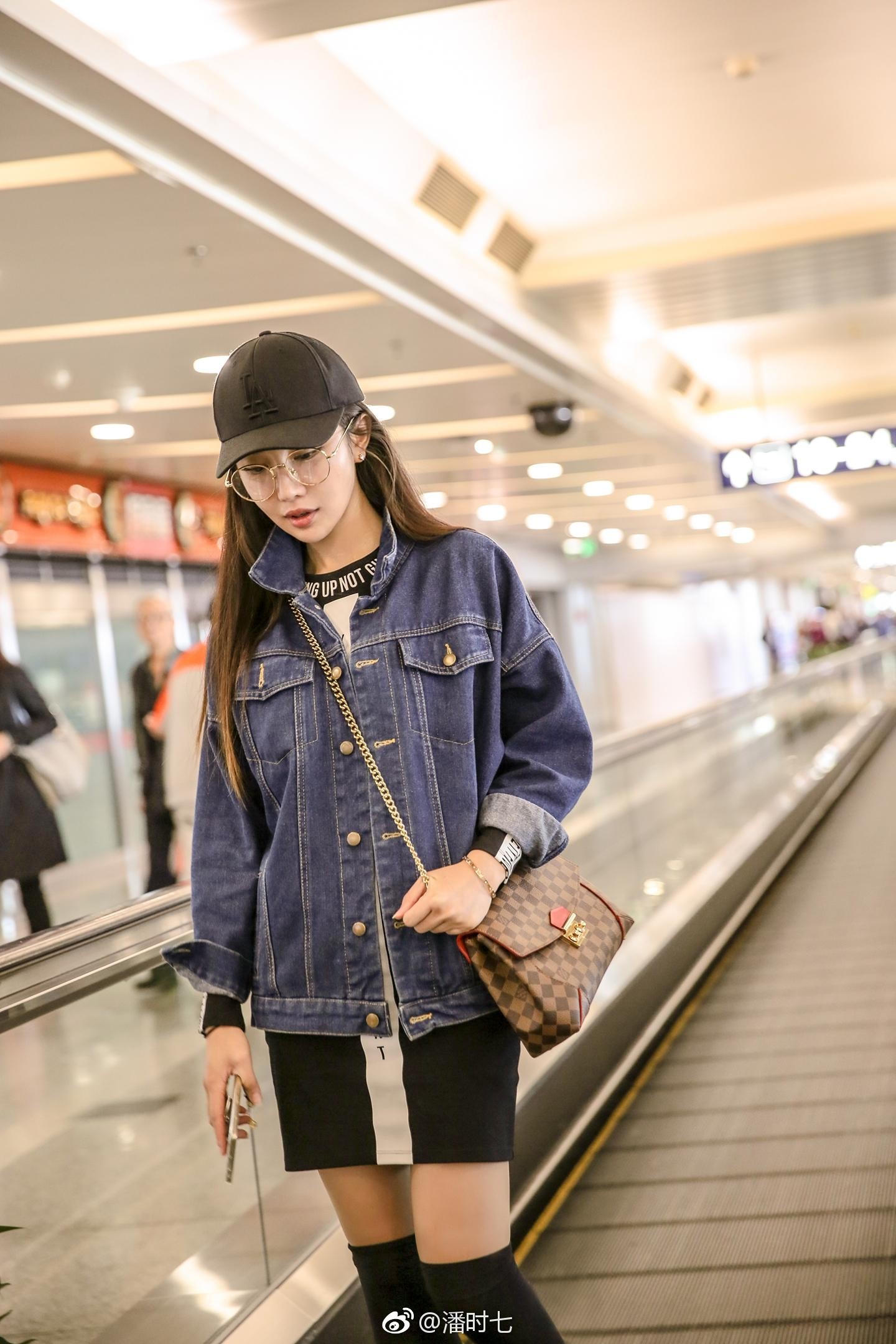 潘时七坐于台阶，牛仔短裤展现率性一面，眼神中透露出从容与坚定的力量