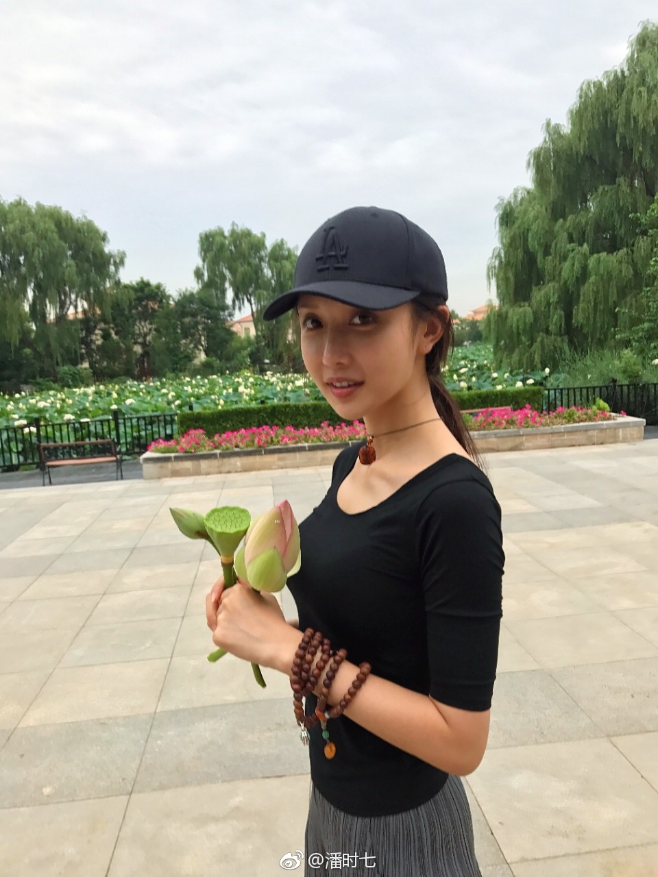 潘时七在都市背景下驻足凝望，整体造型简约利落，散发出独立自信的气场