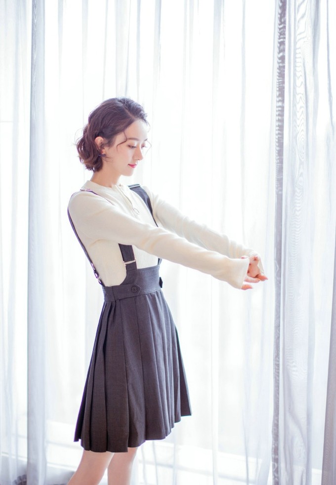 赵丽颖身着浅色长裙倚靠门边，眼神清澈温柔尽显知性气质