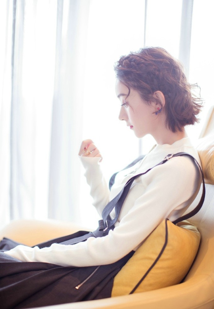 赵丽颖长发垂落眼含笑意，简约黑衣衬托出温婉动人的静谧美感