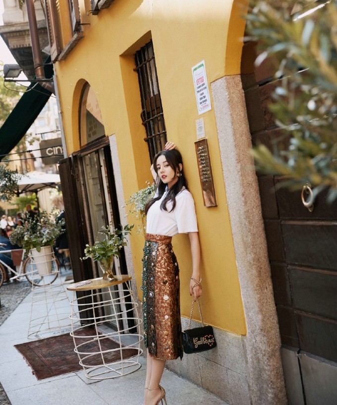 背影渐渐远去，格纹大衣与秋日长街构成一幅复古电影画面