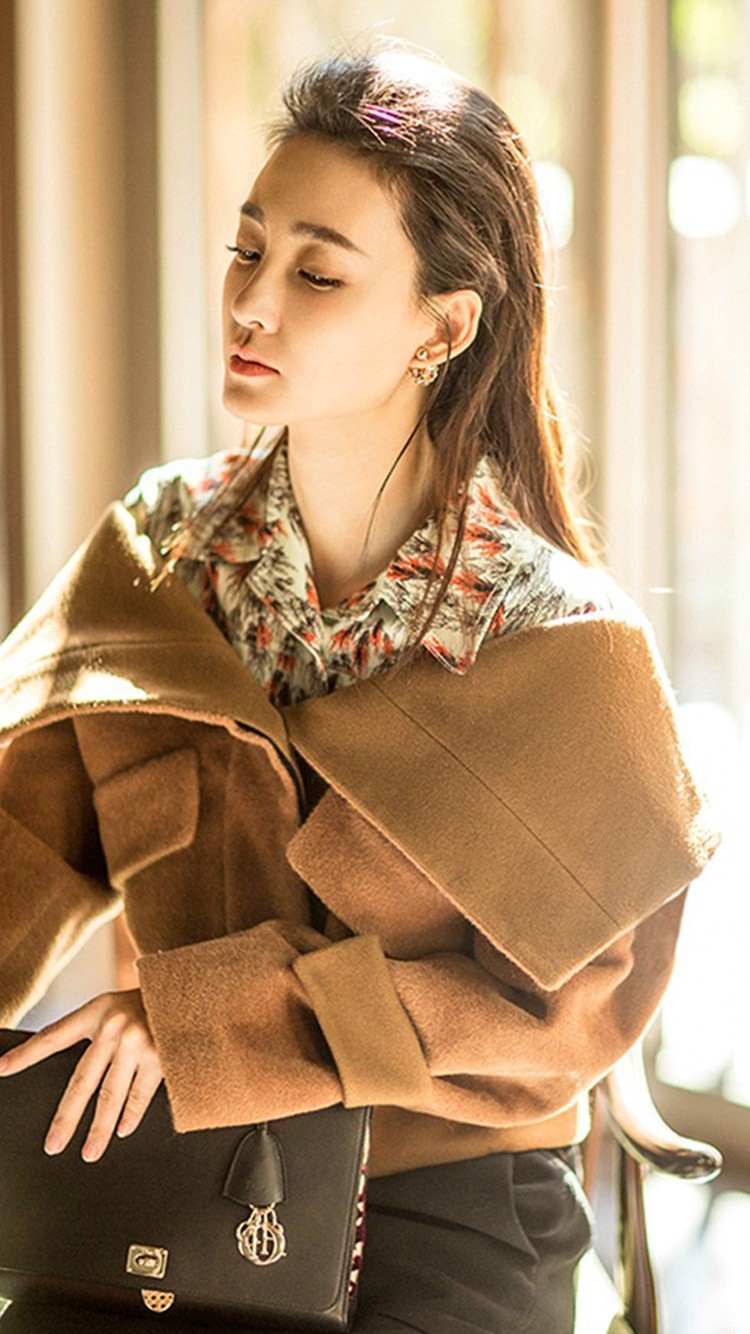 王丽坤身着米白色中式立领上衣立于暖光中，手持玉兔灯侧首浅笑，眉眼间尽显古典温婉