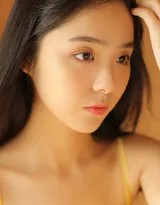 侧身坐在地毯上的美少女，专注阅读杂志，吊带连衣裙衬托清新气质，居家时光静谧美好