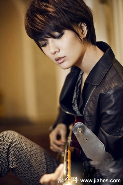 王珞丹身着个性服饰置身于光影交织的背景前，展现冷艳不羁的时尚表现力