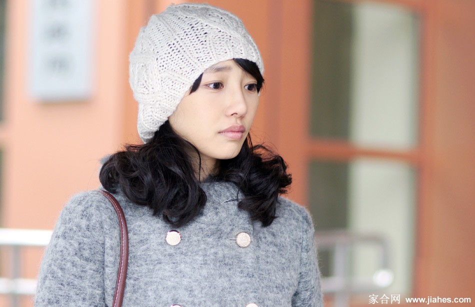 白百何手持咖啡杯坐在咖啡馆角落，暖色调灯光下的沉思时刻