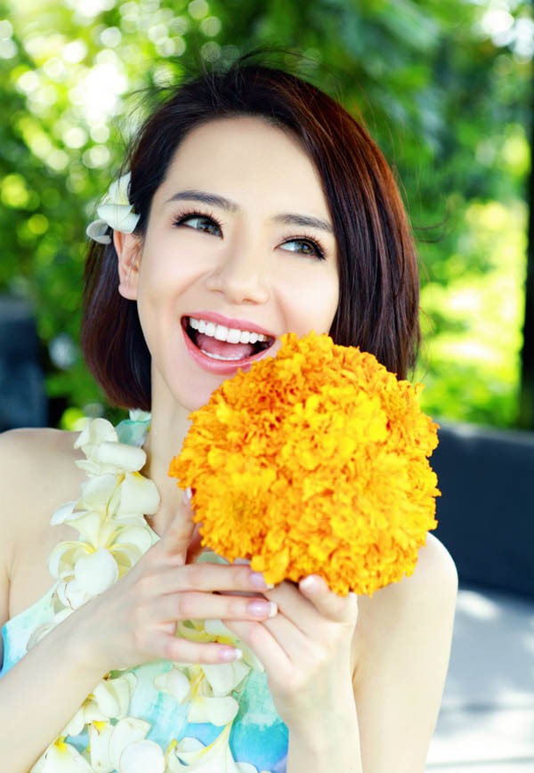 戚薇镜头特写聚焦璀璨笑眼，发丝沾细沙却更添灵动鲜活魅力