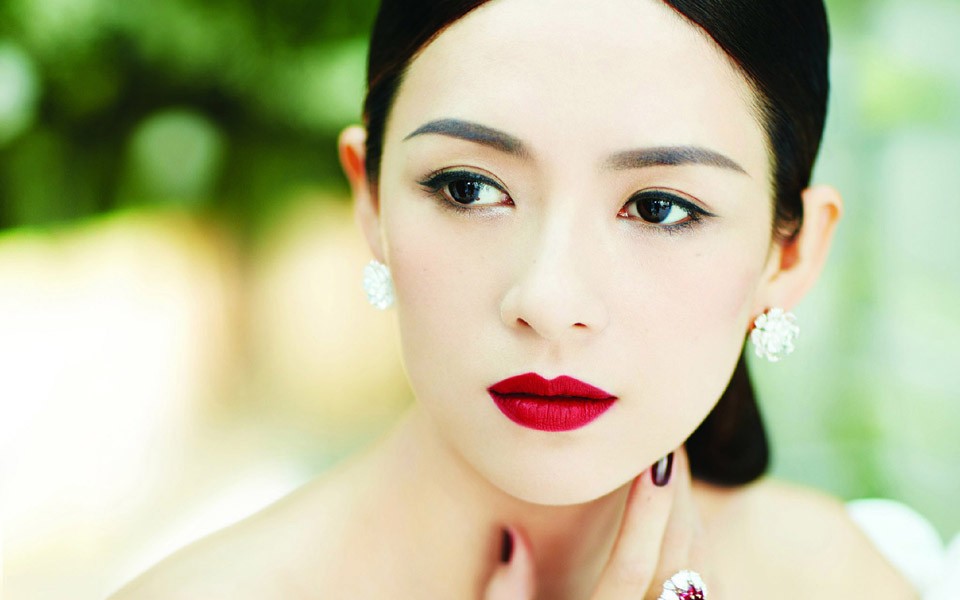 章子怡倚坐于中式雕花窗棂前，姿态慵懒，眼波流转间流露出妩媚柔情与淡淡神伤