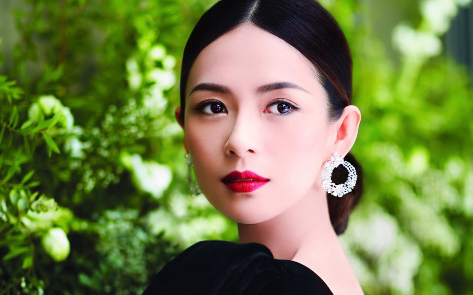 章子怡身穿精致刺绣礼服回眸凝视，古典发髻与华丽珠宝相映，展现极致的东方华贵之美