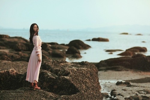 古风女子于落花庭院中撑伞凝望