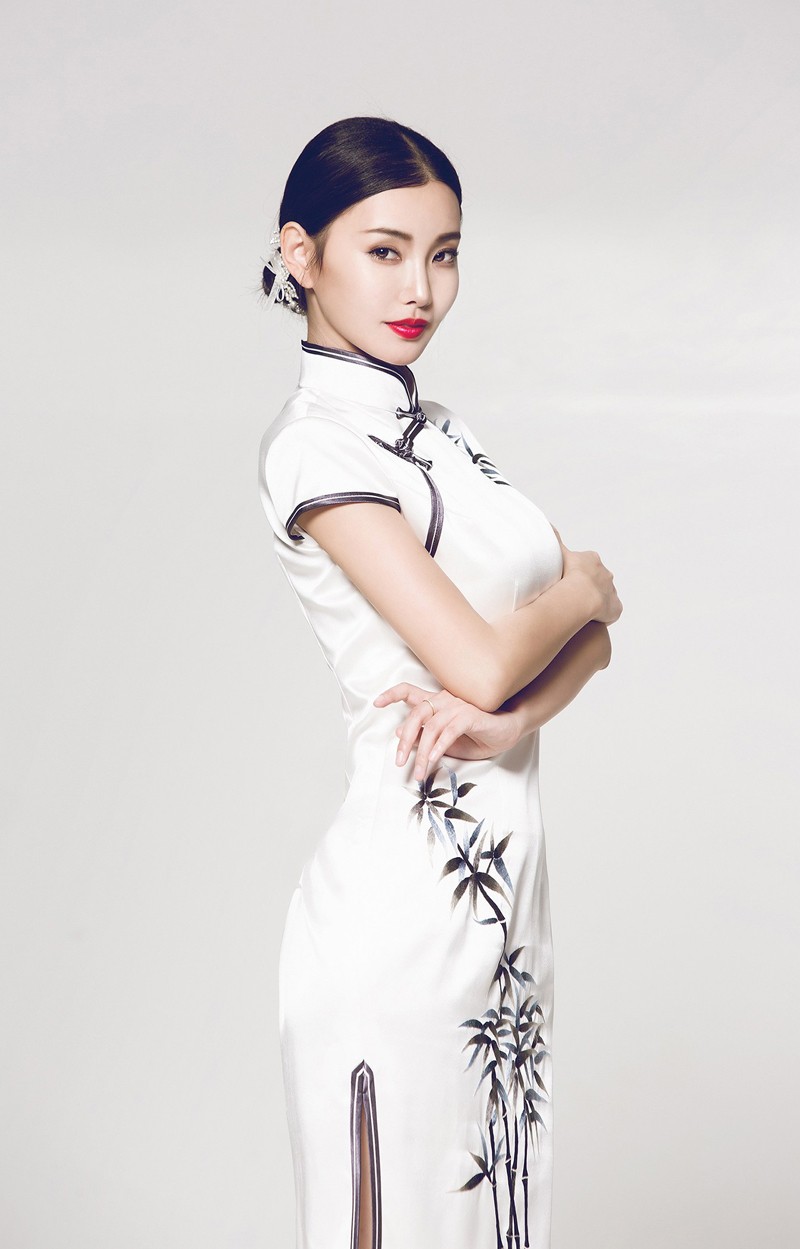 童菲换上精致中式刺绣礼服，手持团扇端庄而立，眼波流转间尽显东方韵味