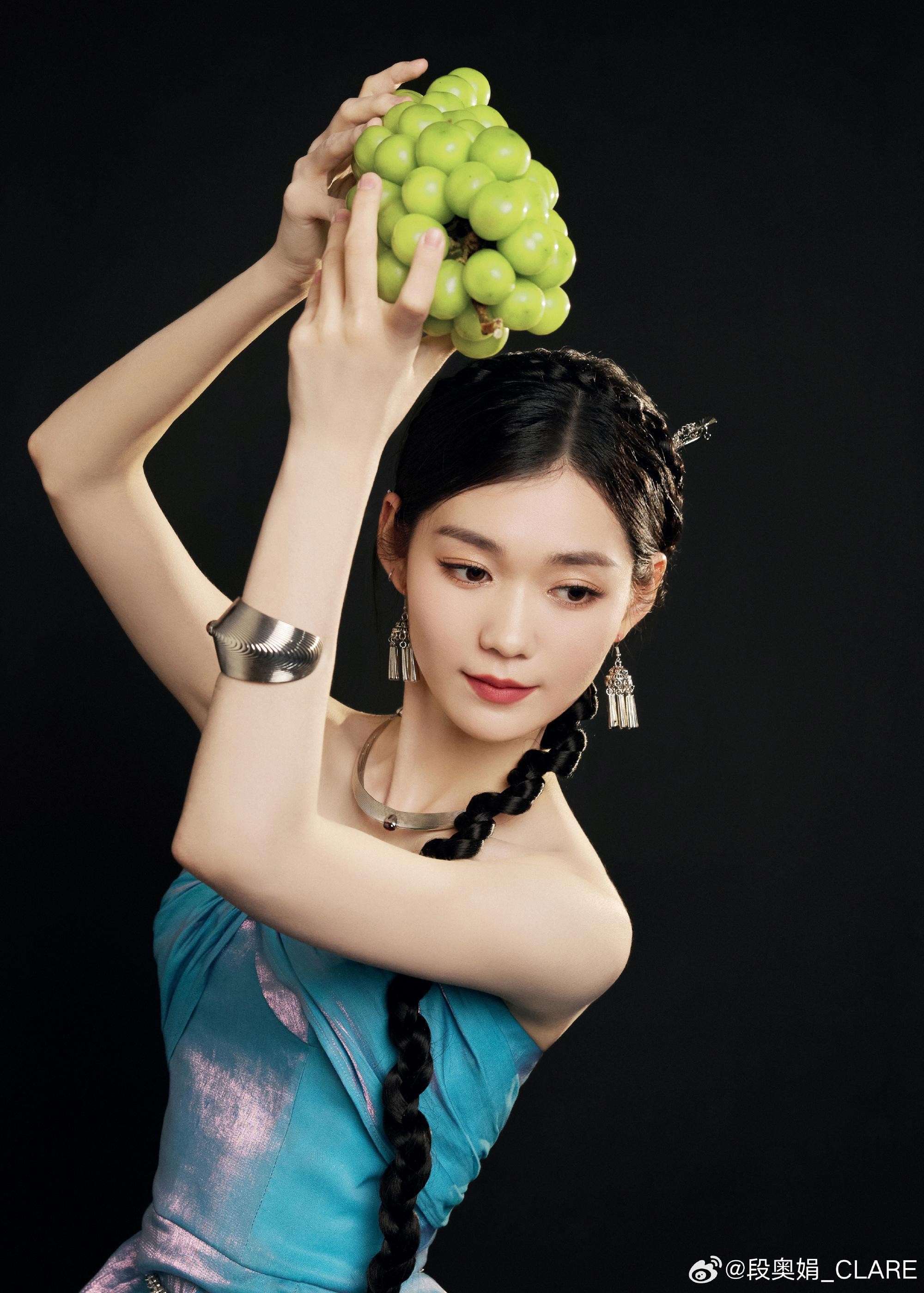 段奥娟一袭优雅长裙侧身而立，柔和光线勾勒出其流畅的身体线条与专注的侧颜