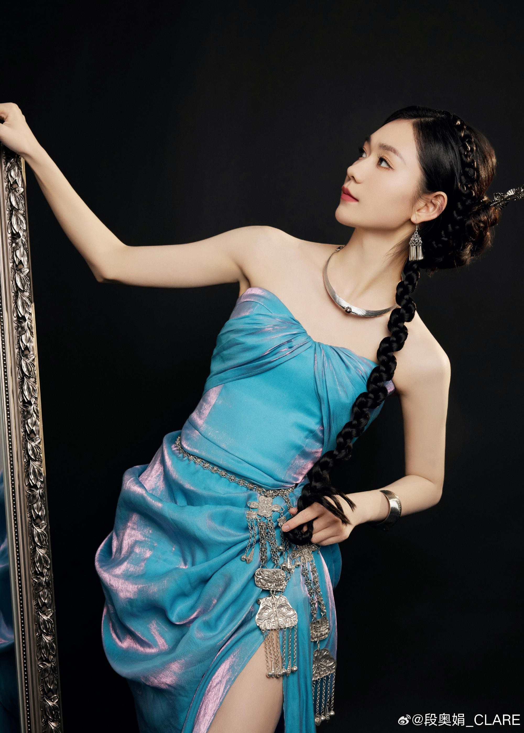 段奥娟身着带有精致细节的裙装，于古典场景中驻足，展现静谧复古的油画质感