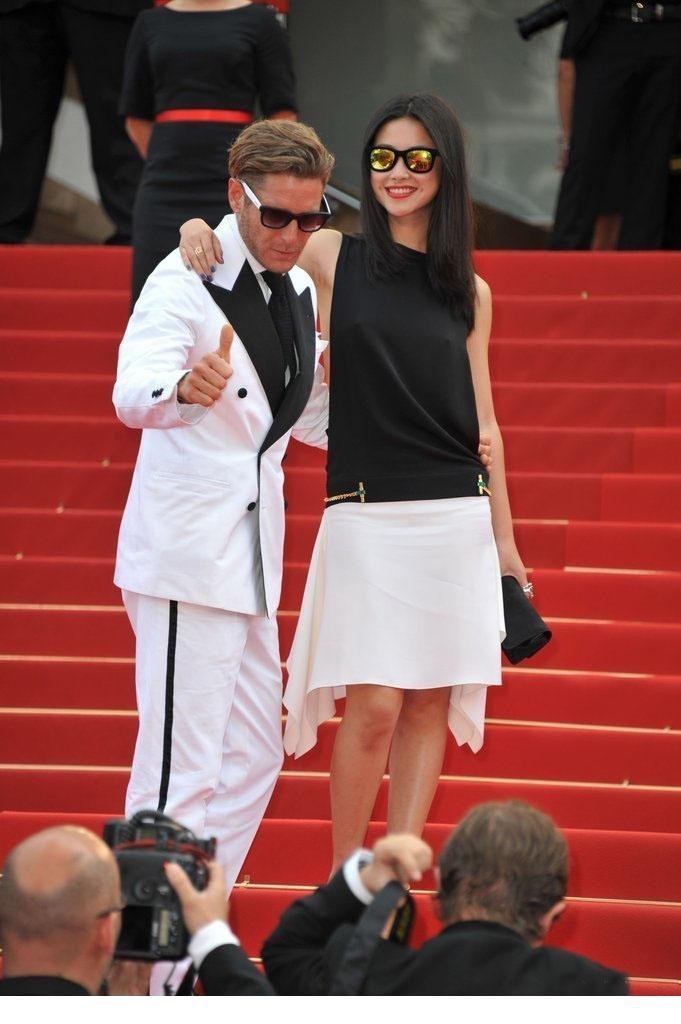 朱珠身着典雅礼服回眸浅笑，戛纳夜幕下身影璀璨如明珠