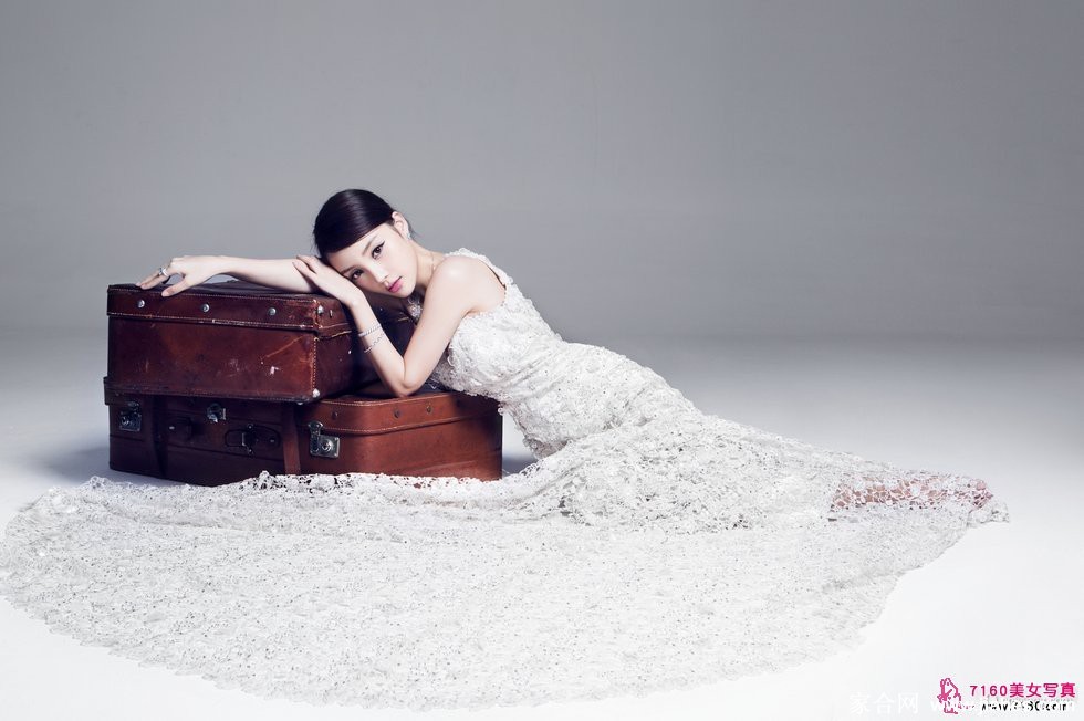 轻倚镜前，指尖掠过洁白头纱，眼眸低垂似在沉思