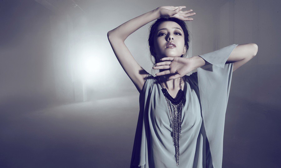 佟丽娅穿着剪裁利落的西装凝视镜头，干练短发造型搭配红唇，展现强大气场