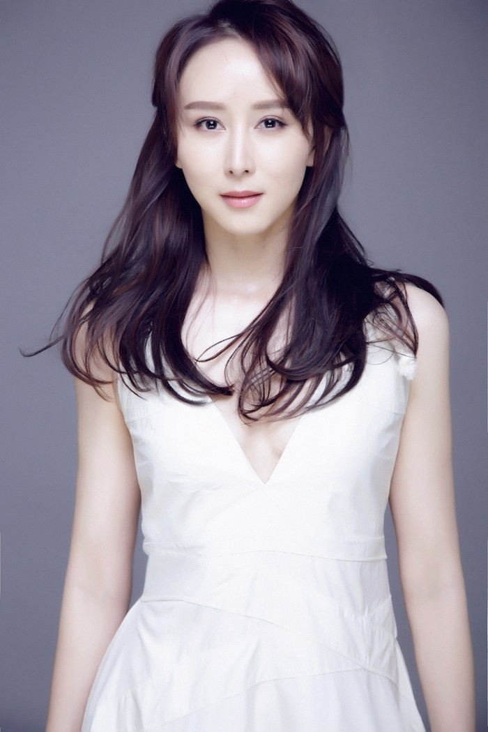 胡静倚靠窗边，眼神温柔望向远方，静谧中透露出岁月静好的氛围