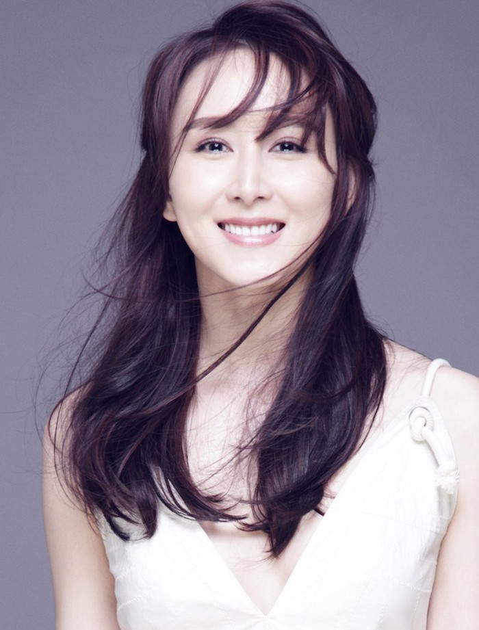 胡静身着白色深V长裙侧身而立，光影勾勒出其优雅侧颜与精致锁骨线条