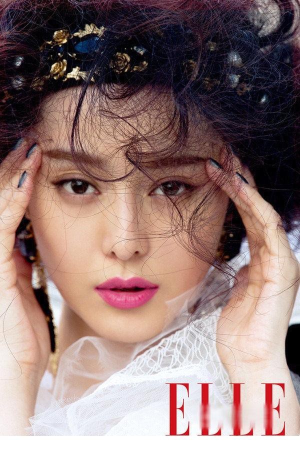 光影间范冰冰手持皮包，皮草质感与时尚气场浑然一体