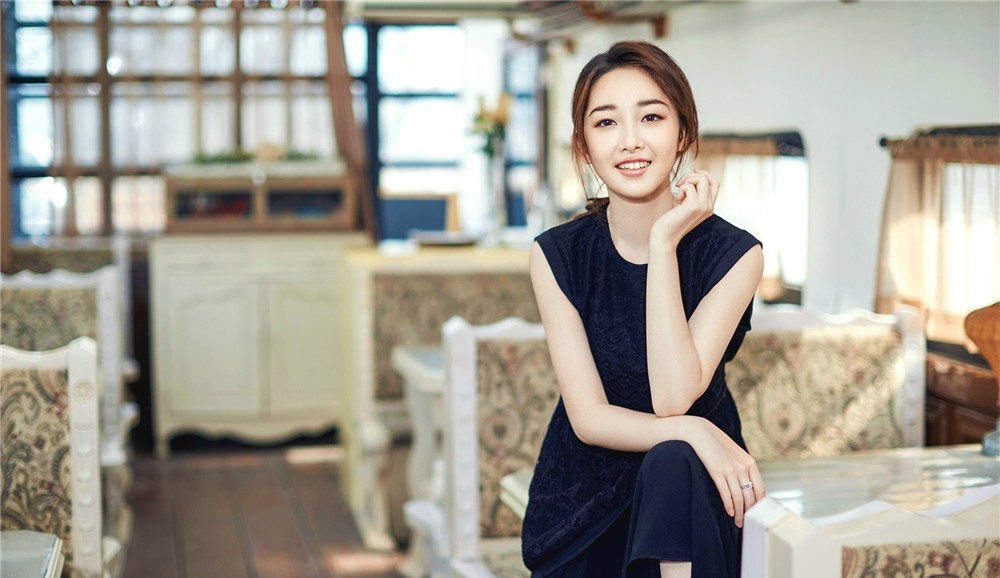 蒋梦婕手拈花瓣低头细嗅，静谧侧颜勾勒出温柔娴雅的轮廓